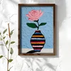 WallXpert uramljena MDF slika NAL107-70, roze ruža u prugastoj vazi na svetloplavoj pozadini, 50 x 70 cm