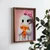 WallXpert uramljena MDF slika NAL086-46, duh sa roze mašnom jede parče pice na roze pozadini, 35,5 x 47 cm